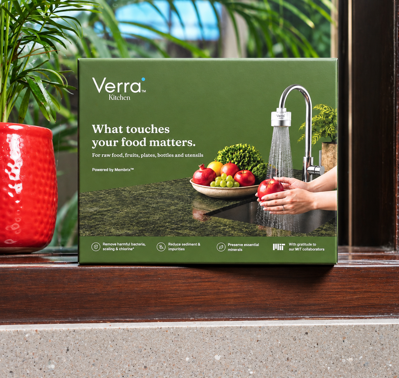 Verra Kitchen product box on a windowsill with a red planter and greenery.